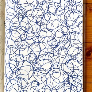 A sample image of pattern designs using hand carved rubber stamps available in the shop. This one shows the repeat pattern of layered doodle lines, stamped in blue.