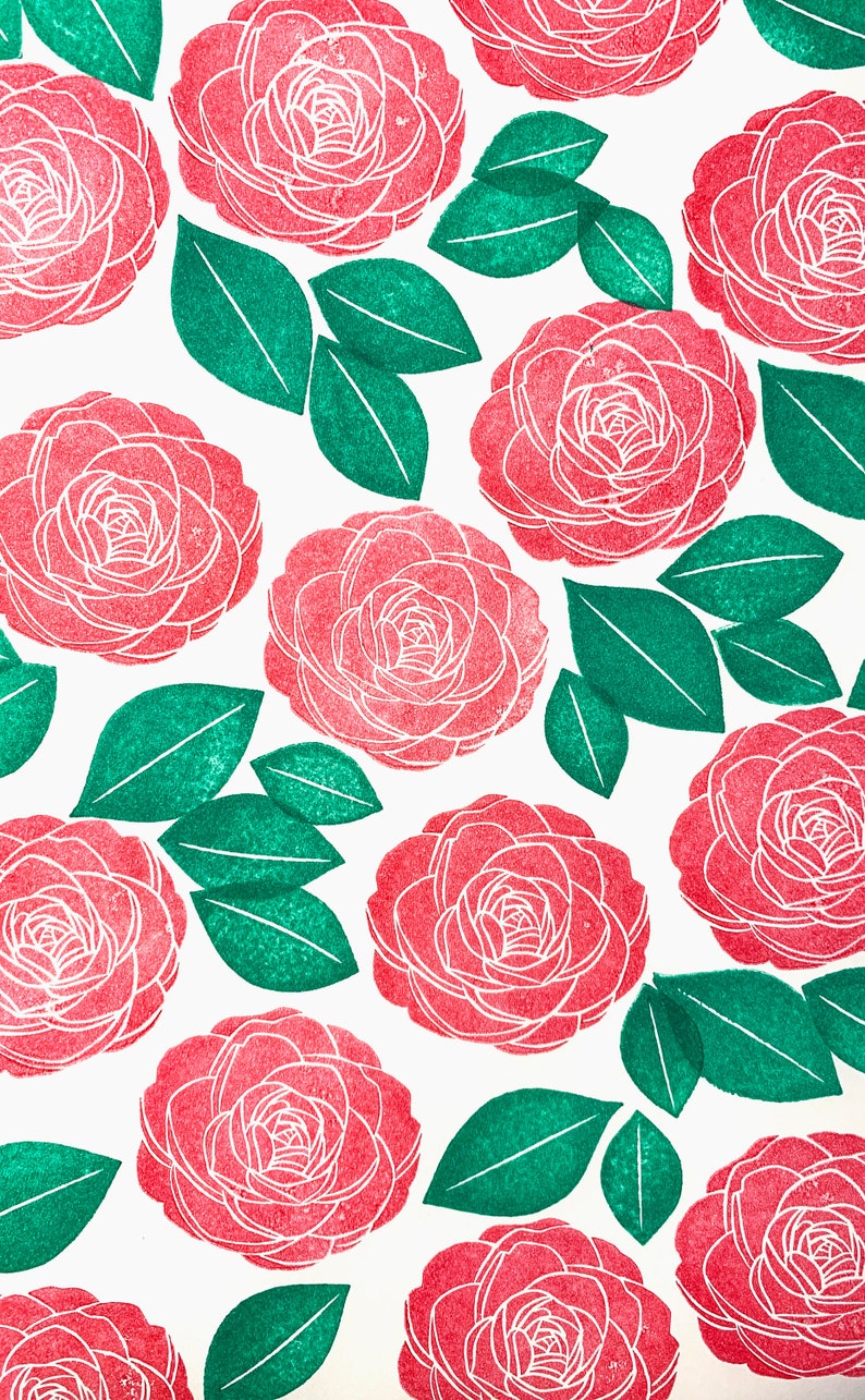 A sample image of pattern design using hand carved rubber stamps available in the shop. Camellia flowers are stamped in red and leaves are in green.