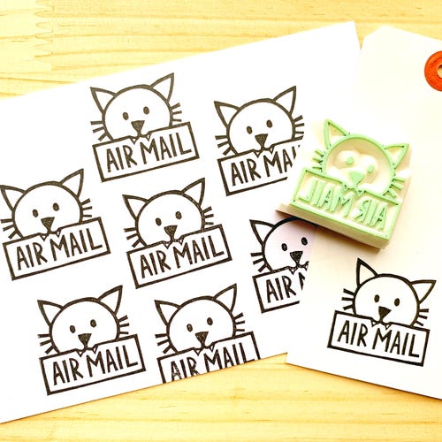 Gato tallado a mano sosteniendo un sello de goma de correo aéreo: Correo postal