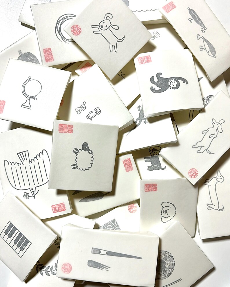 A sample image of packagings for hand carved rubber stamps - wrapped with glassine paper and a stamped example card.