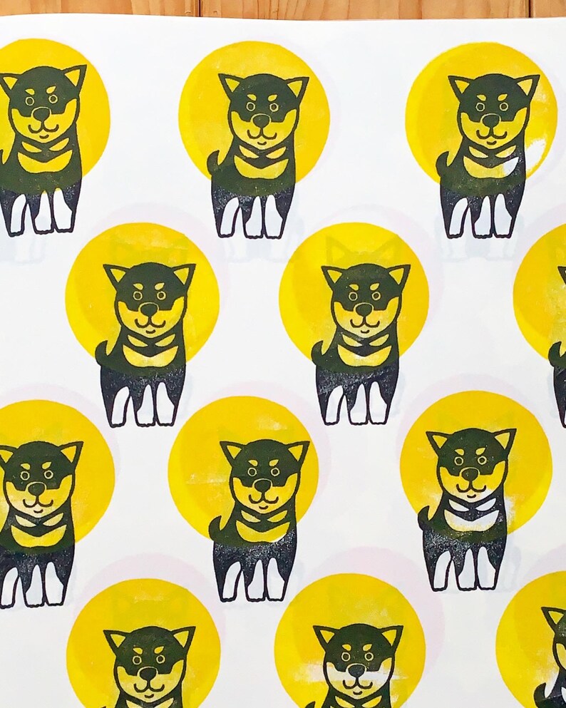 A sample image of pattern design using hand carved rubber stamps available in the shop. Shiba Inu puppies in black and circles in yellow.