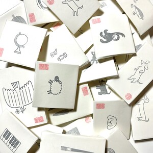 A sample image of packagings for hand carved rubber stamps - wrapped with glassine paper and a stamped example card.