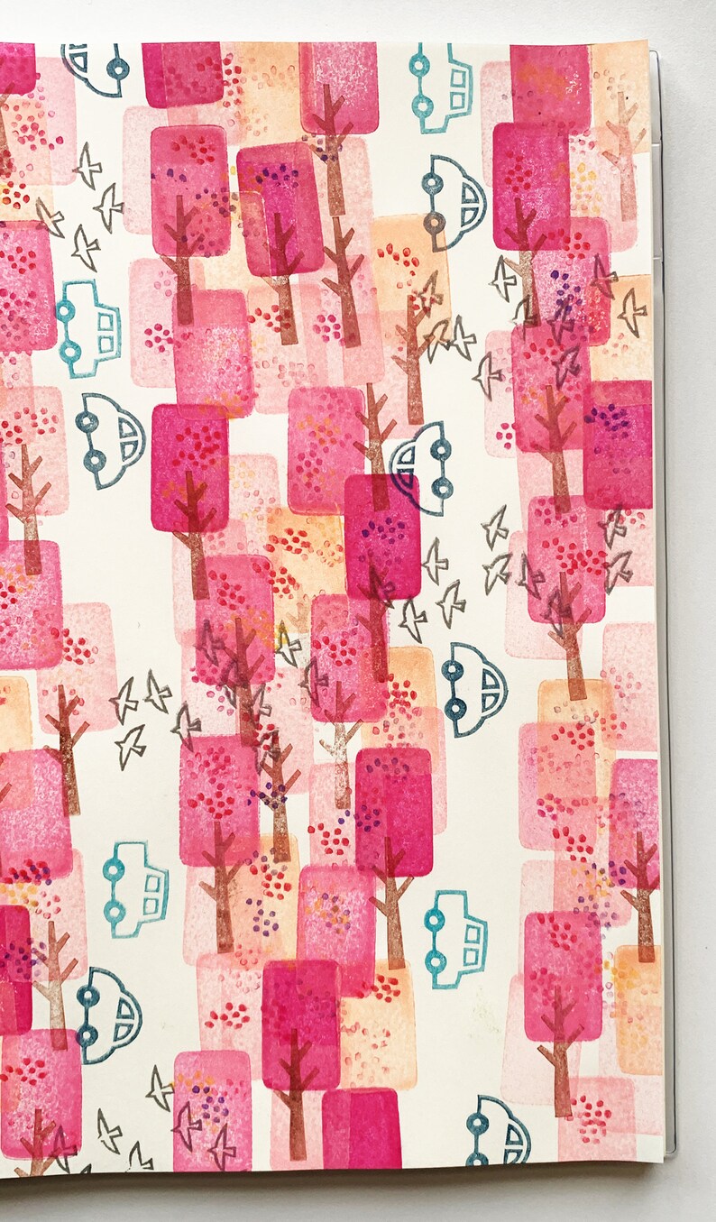 May include: A white background with a repeating pattern of pink and orange squares with brown tree trunks and branches.  Small gray birds are flying between the trees.  There are also small blue cars with white wheels.