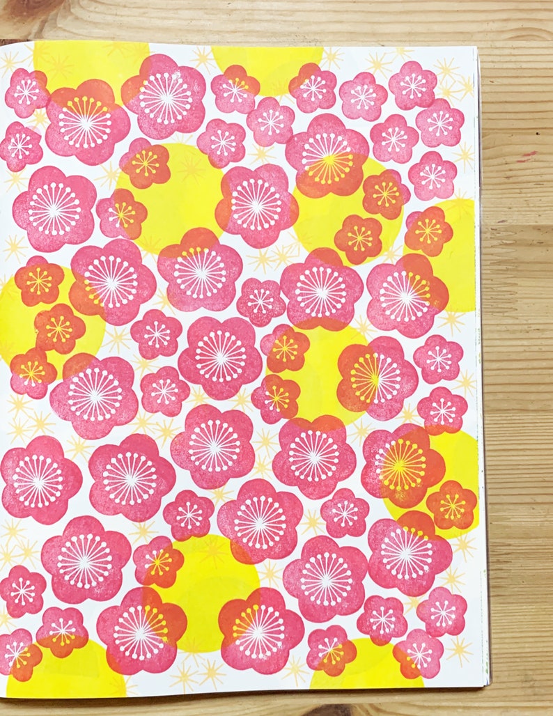 A sample image of pattern design using hand carved rubber stamps available in the shop to share ideas for art and craft projects. This one shows plum blossoms in red and yellow circles and little flowers on the background.