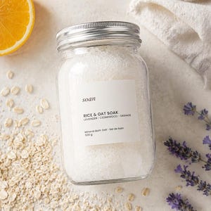 Jar of Rice and Oat bath soak containing pale mineral salts with finely powdered rice and oats.