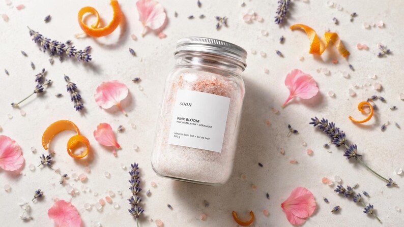 Clear jar of pink mineral bath salts made with pink Himalayan salt and a lavender-geranium fragrance