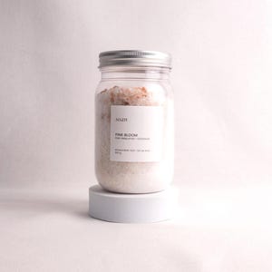 Mineral bath salt gift set with five soak blends including floral, herbal, recovery, and milk bath options in minimalist packaging.