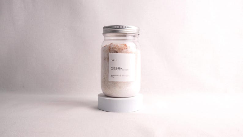 Mineral bath salt gift set with five soak blends including floral, herbal, recovery, and milk bath options in minimalist packaging.