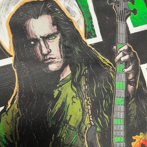 May include: A black and green illustration of a person with long black hair playing a bass guitar. The person is wearing a green shirt and has a halo above their head.