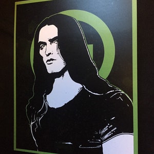 May include: Black and white illustration of a person with long black hair, wearing a black shirt. The background is black with a green circle.