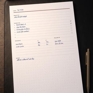 May include: A white paper planner sheet with black text and lines, featuring sections for Date, Objective, Priorities, Delegate, To, By, Follow Up, and Notes. The sheet includes handwritten entries like "close the Q4 budget" and "book flights."