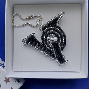 Um pingente amuleto original e lindo de dupla face "Letra V", bordado com contas checas.