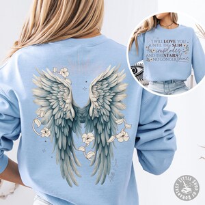 May include: Light blue sweatshirt with a graphic of angel wings and flowers on the back. The text "I will love you until the sun implodes and the stars no longer shine" is printed on the front of the sweatshirt.