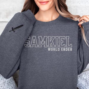 May include: A dark gray sweatshirt with the text "SAMKIEL WORLD ENDER" printed in white on the front.