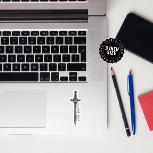 May include: A sticker featuring a detailed illustration of a sword with a heart-shaped hilt and the text "DIRE BOUND." The sticker is approximately 3 inches in size and is on a white background.