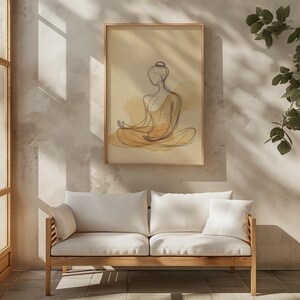 K&ouml;nnte beinhalten: Eine minimalistische Linienzeichnung einer Person in sitzender Meditationspose, mit einer Aquarell-Waschung in Gelb- und Braunt&ouml;nen. Die Zeichnung ist gerahmt und h&auml;ngt an einer Wand &uuml;ber einem wei&szlig;en Sofa.