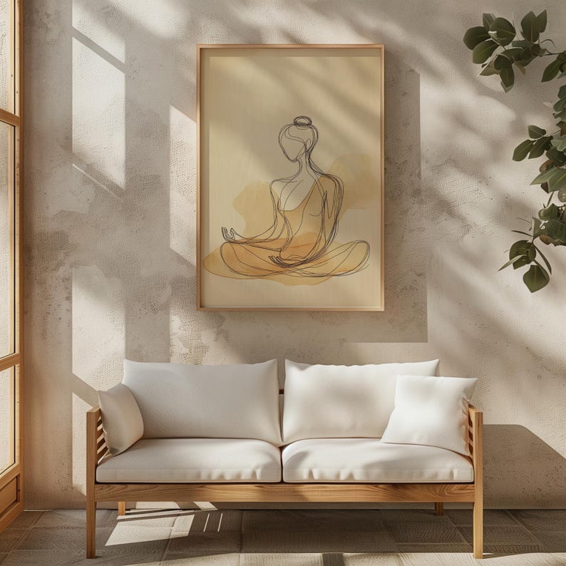 K&ouml;nnte beinhalten: Eine minimalistische Linienzeichnung einer Person in sitzender Meditationspose, mit einer Aquarell-Waschung in Gelb- und Braunt&ouml;nen. Die Zeichnung ist gerahmt und h&auml;ngt an einer Wand &uuml;ber einem wei&szlig;en Sofa.