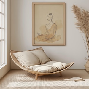 K&ouml;nnte beinhalten: Ein heller Holzstuhl mit zwei beigen Kissen. Der Stuhl ist gebogen und hat ein einzigartiges Design. Der Stuhl steht vor einer beige Wand mit einem gerahmten Druck eines Strichm&auml;nnchens, das in meditativer Pose sitzt.