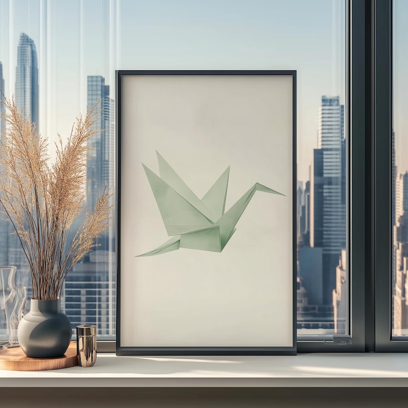 May include: A framed print of a green origami crane against a white background. The print is in a black frame and is hanging on a wall.