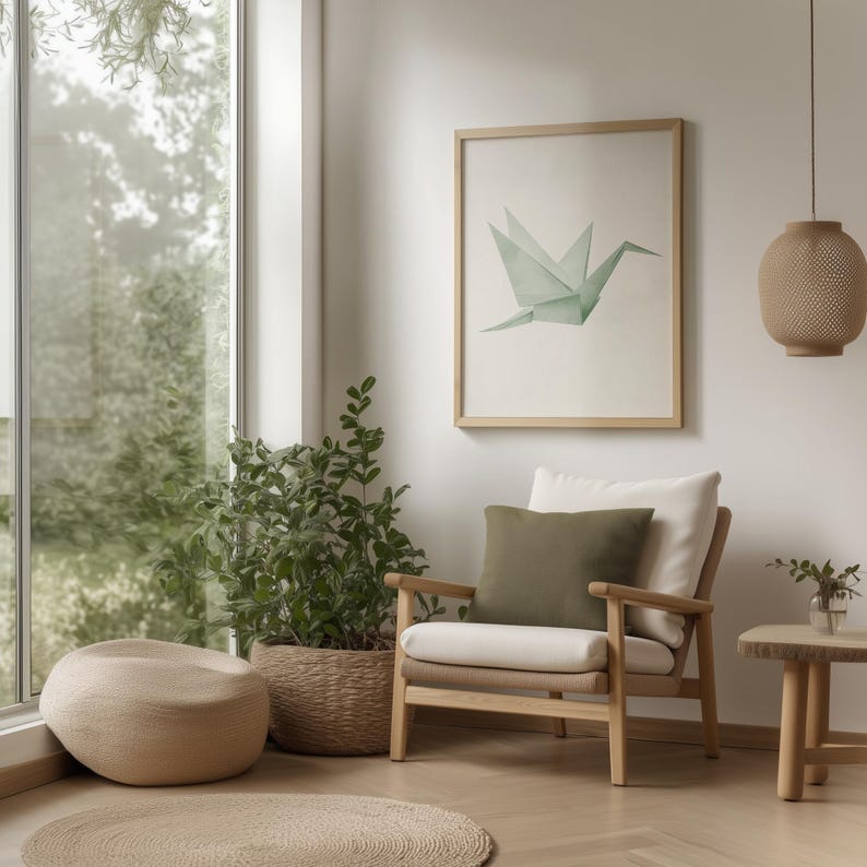 May include: A light wood armchair with a white cushion and a green throw pillow sits in a living room with a large window, a potted plant, and a framed print of a green origami crane.