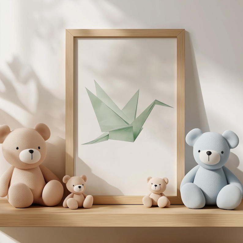 May include: Three teddy bears, one light brown, one light blue, and one tan, are sitting on a wooden shelf in front of a framed print of a green origami crane.