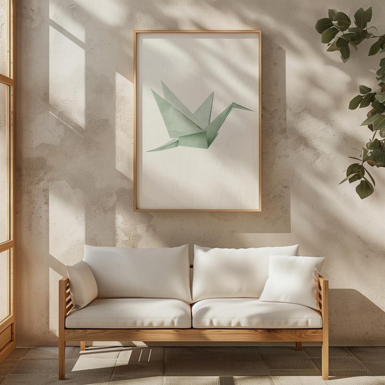 May include: A white sofa with a wooden frame sits in a room with a framed print of a green origami crane. The wall is a light beige color.