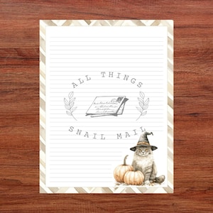 May include: Lined stationery with a decorative border and the words "ALL THINGS SNAIL MAIL." The design features a watercolor illustration of a cat wearing a witch hat, pumpkins, and a vintage letter.