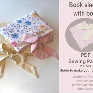 May include: A floral book sleeve with a pink bow and a cream-colored bow. The book sleeve is white with blue and pink flowers. The image also includes a PDF sewing pattern with instructions to make your own book sleeve.