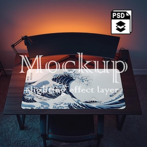 以下が含まれることがあります： 大きな海の波の青と白のイラストが描かれた長方形の白いマウスパッド。背景には小さなボートと山があります。マウスパッドは木製の机の上にあります。