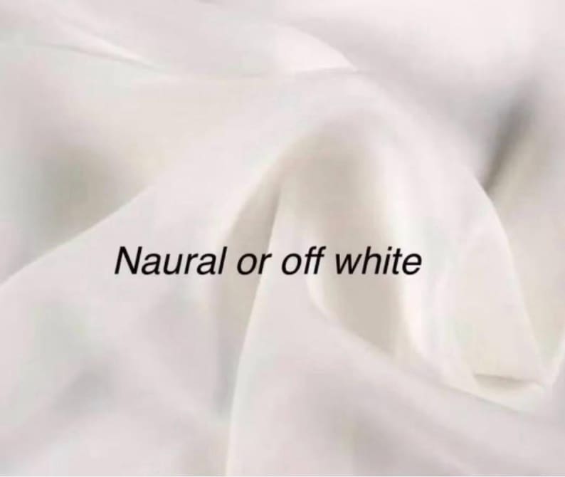 Op de afbeelding: Off-white stof met zachte plooien. De tekst "Natural or off white" is op de stof gedrukt. De stof lijkt glad en vloeiend te zijn, met subtiele kleurvariaties.