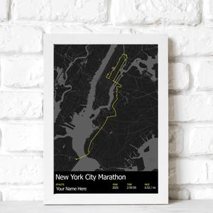 May include: A framed print featuring a map of New York City with a yellow route highlighting the New York City Marathon course. The text "New York City Marathon" is at the bottom, along with athlete details, year 2025, time 2:59:59, and pace 6:52/mi.