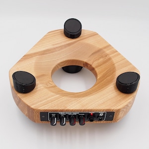 May include: A wooden triangular turntable base with four black rubber feet and a control panel with four knobs and a jack. The panel has the text "HEX Analog Preamp" printed on it.