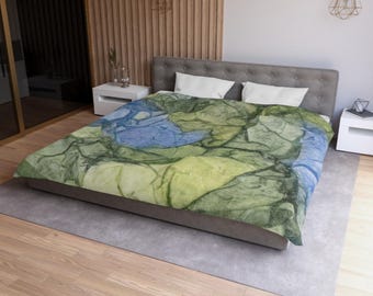 May include: A green and blue abstract patterned duvet cover with a modern design. The duvet cover is on a bed with white pillows.