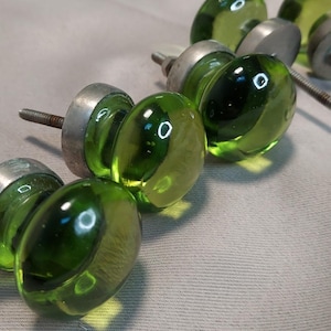 May include: A white ceramic mug with a black handle and the text "But First, Coffee" in a black, handwritten-style font. The mug is on a white surface.