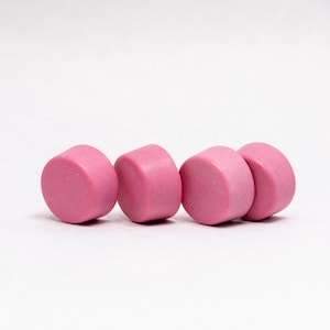 以下が含まれることがあります： ピンクの丸いセラミックノブが4つ、一列に並んでいます。