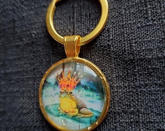 Llavero colgante con cabujón de círculo dorado del Príncipe Rana, obra de arte original decorada a mano por la artista Heather Calderon.