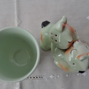 Puede incluir: Una taza de cer&aacute;mica blanca con asa negra y el texto "But First, Coffee" en negrita negra. La taza se muestra sobre una superficie blanca, mostrando su dise&ntilde;o limpio.