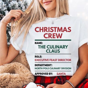 May include: A white short-sleeved t-shirt featuring the red and green text CHRISTMAS CREW, NAME: THE CULINARY CLAUS, ROLE: EXECUTIVE FEAST DIRECTOR, DEPARTMENT: NORTH POLE CULINARY DIVISION, and APPROVED BY: SANTA, arranged in a structured list format.