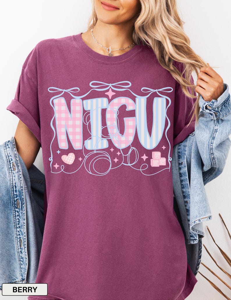 May include: A maroon oversized t-shirt with a graphic design that says "NICU" in pink and blue checkered and striped letters. The graphic also includes hearts, stars, and pacifiers.
