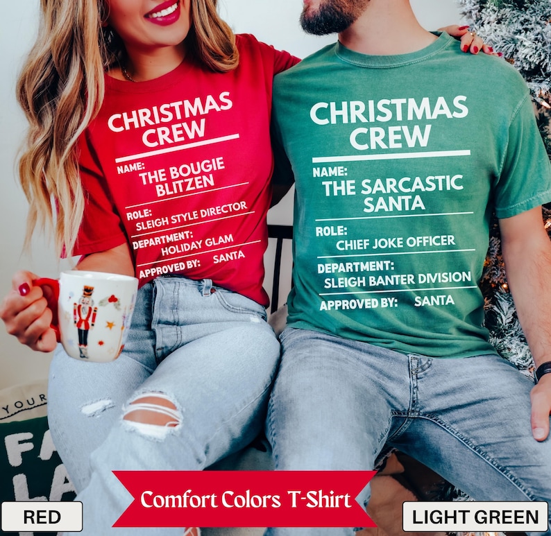 May include: A red t-shirt with white text reading CHRISTMAS CREW, THE BOUGIE BLITZEN, SLEIGH STYLE DIRECTOR, HOLIDAY GLAM, and SANTA, and a green t-shirt with white text reading CHRISTMAS CREW, THE SARCASTIC SANTA, CHIEF JOKE OFFICER, SLEIGH BANTER DIVISION, and SANTA.