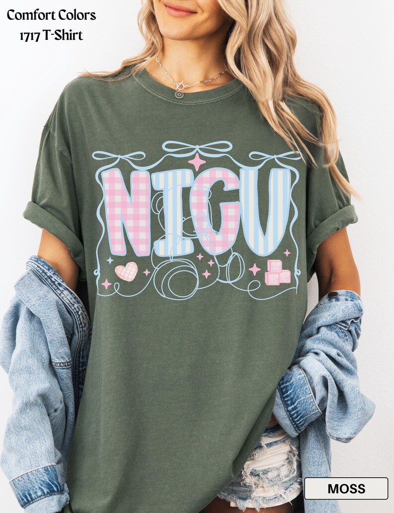 May include: A moss green t-shirt with a graphic of the word "NICU" in pink and blue checkered and striped patterns. The graphic is surrounded by hearts, stars, and blocks.