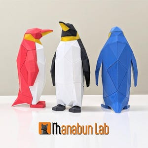 May include: Three penguin figurines made of geometric shapes. The penguins are red, white, and blue.