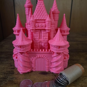 May include: A pink plastic castle-shaped money box with a slot in the front and a roll of coins spilling out of the top.