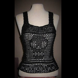 Puede incluir: Top de crochet negro con escote cuadrado y un delicado patrón de calado.