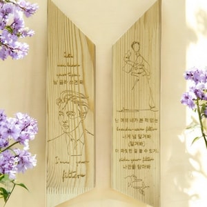 May include: Two wooden plaques with a light brown wood grain. The left plaque features a line drawing of a man's face and the text "I'm your filter". The right plaque features a line drawing of a person with their arms raised and the text "난 여태 네가 본 적 없는 brand-new filter 내게 널 맡겨봐 (맡겨봐) 더 짜릿한 걸 할 수 있게 filter your filter 나만을 담아봐".