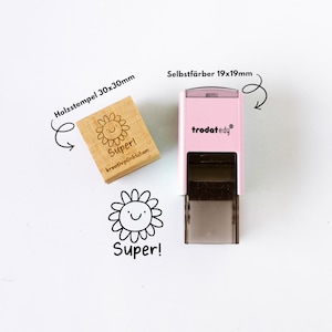 May include: A wooden stamp (30x30mm) and a pink self-inking stamp (19x19mm) with a smiling flower design and the word "Super!". The wooden stamp has the text "kreativp&uuml;nktchen" below the flower.