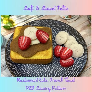 Może przedstawiać: Zestaw francuskich tostów z filcu na dekoracyjnym talerzu. Tosty są zwieńczone brązowym filcem, białymi plasterkami banana z filcu i czerwonymi truskawkami z filcu. Widoczny jest tekst "Soft & Sweet Felts" i "Restaurant Eats: French Toast PDF Sewing Pattern".