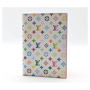 May include: A white passport cover featuring a repeating multicolored monogram pattern of flowers, stars, and the letters LV. The design includes various shades of blue, green, yellow, orange, pink, and purple printed across the textured surface.