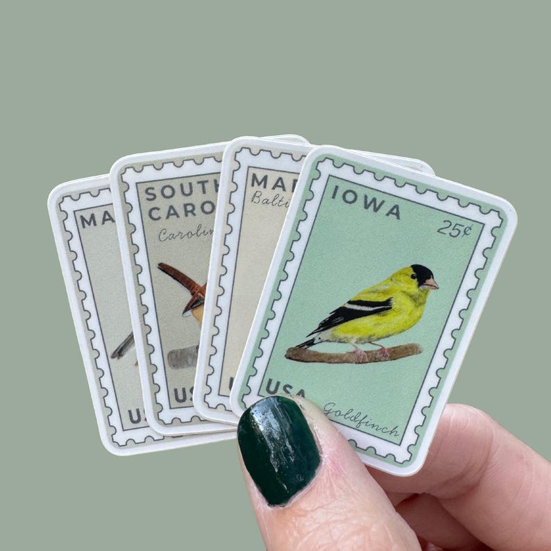 May include: A collection of four rectangular stickers resembling vintage postage stamps. Each sticker features a different bird illustration and state name, including Iowa, South Carolina, and Massachusetts. The Iowa sticker shows a yellow Goldfinch and the price 25&cent;.