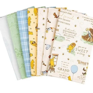 May include: A set of six folded fabric pieces featuring various designs including a solid white, a light green map print, a blue plaid, a yellow Winnie the Pooh pattern, a cream bee print, and a cream panel with Winnie the Pooh illustrations and text.